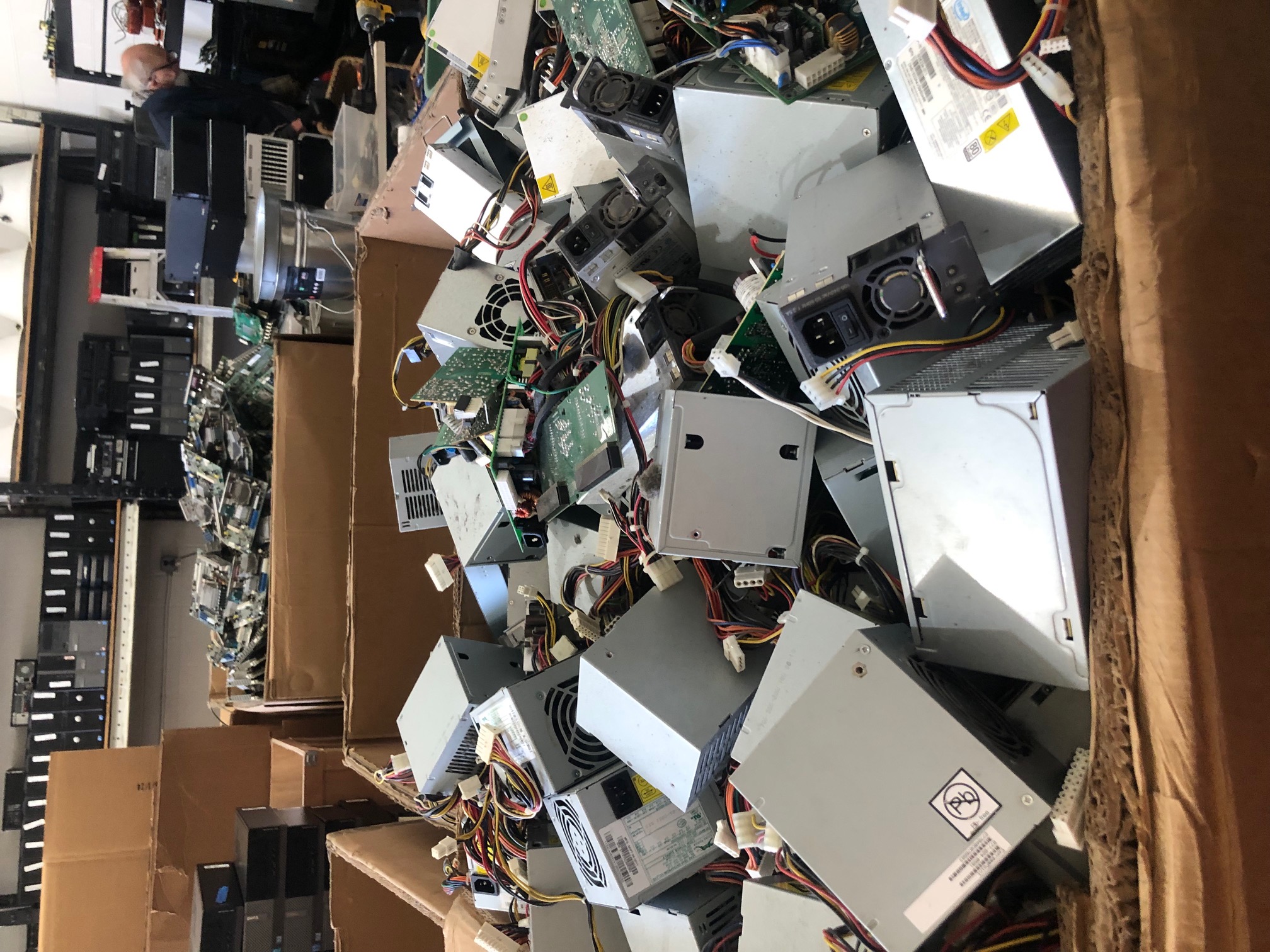 A stack of used desktop computers and older computer hardware